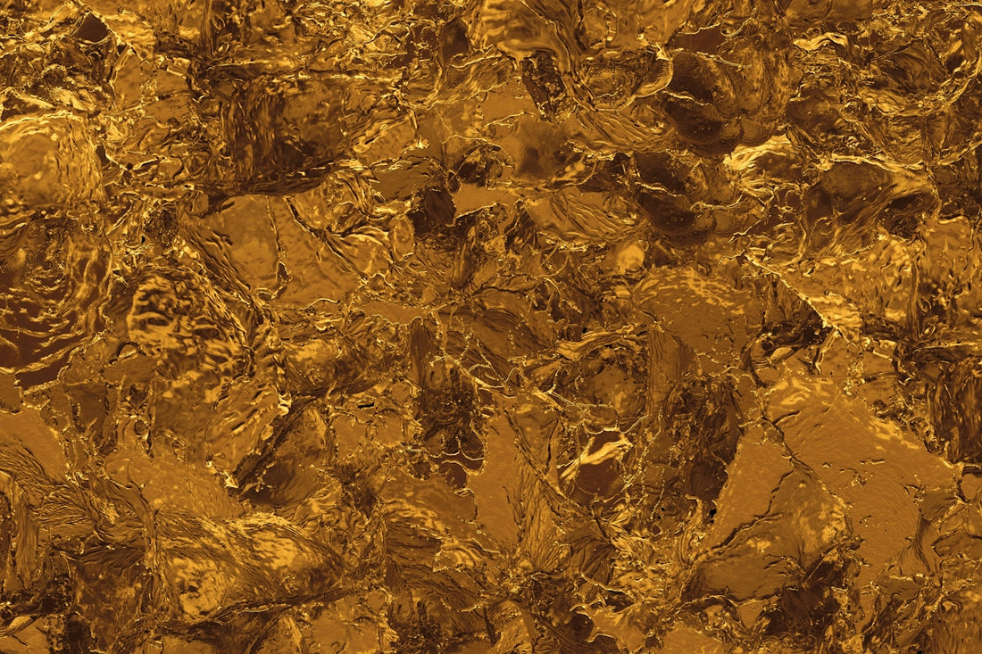 A textured surface of molten gold with irregular ripples and reflective highlights