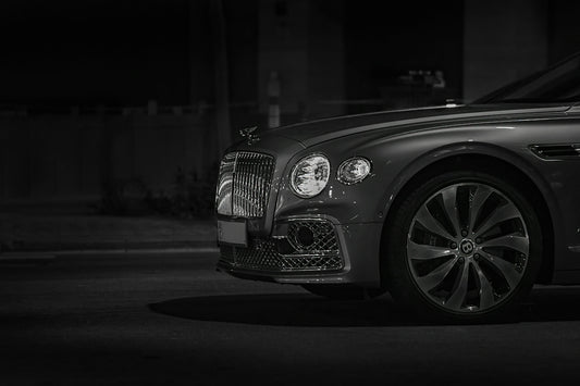 Front view of a luxury car with a chrome grille at night